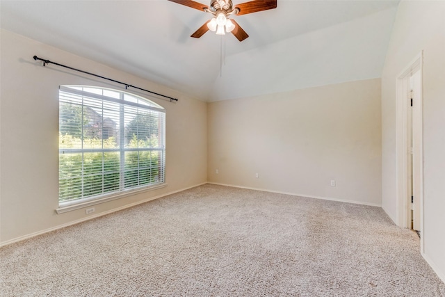 carpeted spare room featuring lofted ceiling, baseboards, and ceiling fan