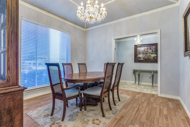 dining space featuring crown molding, a notable chandelier, wood finished floors, and baseboards