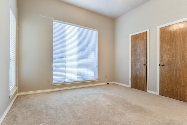 unfurnished bedroom with carpet flooring and multiple closets