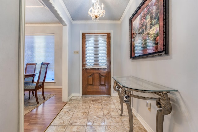 foyer featuring a textured ceiling, an inviting chandelier, plenty of natural light, and ornamental molding