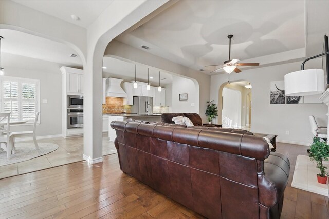 108 Zion Ln, Forney, TX 75126 - living area featuring arched walkways, a ceiling fan, wood-type flooring, and baseboards