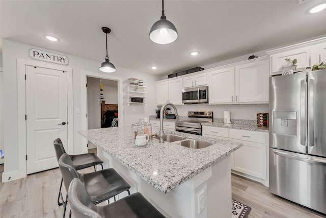 1403 Franklin Ave, Bonham, TX 75418 - kitchen with appliances with stainless steel finishes, white cabinetry, light wood-style flooring, and recessed lighting