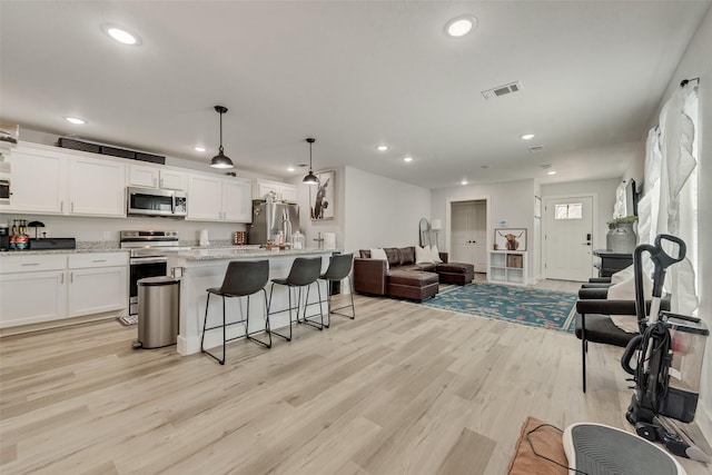 1403 Franklin Ave, Bonham, TX 75418 - kitchen featuring appliances with stainless steel finishes, recessed lighting, open floor plan, white cabinets, and light wood-style flooring