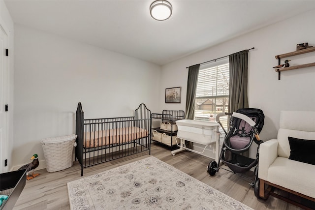 1403 Franklin Ave, Bonham, TX 75418 - bedroom with wood finished floors, a crib, and baseboards