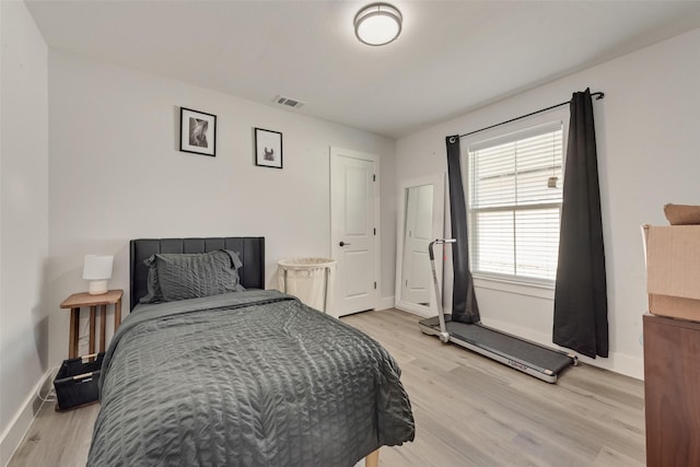 bedroom with light wood-type flooring, visible vents, and baseboards