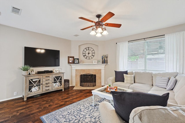 living room with visible vents, wood finished floors, a fireplace, baseboards, and ceiling fan