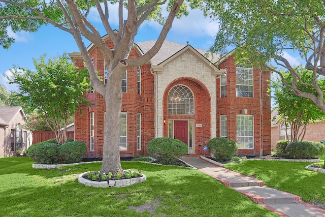 view of front facade with stone siding, brick siding, and a front lawn