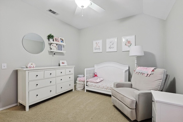 bedroom featuring visible vents, a crib, baseboards, light colored carpet, and vaulted ceiling