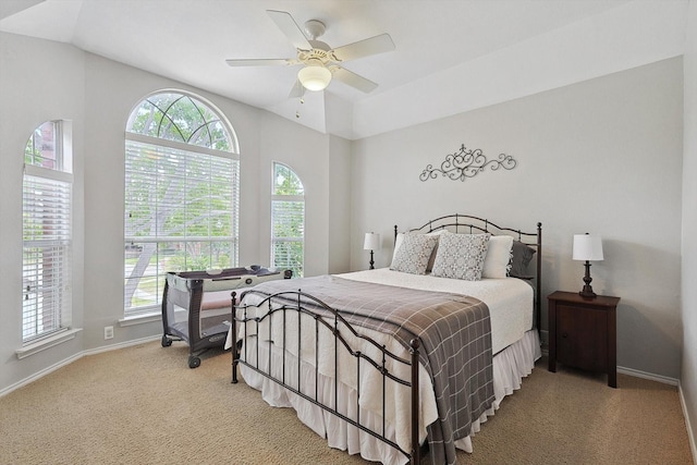 bedroom featuring baseboards, light carpet, lofted ceiling, and a ceiling fan