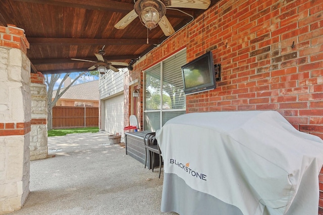 view of patio / terrace with fence, a garage, and ceiling fan