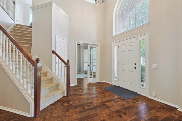 foyer entrance with stairs, baseboards, and wood-type flooring