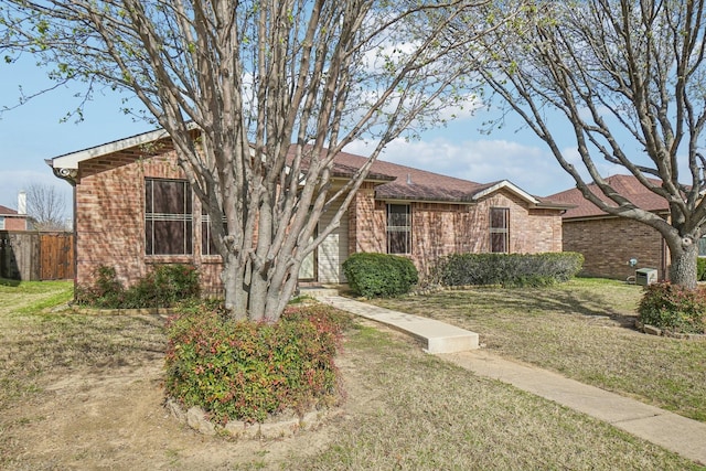 single story home with brick siding, a front lawn, and fence