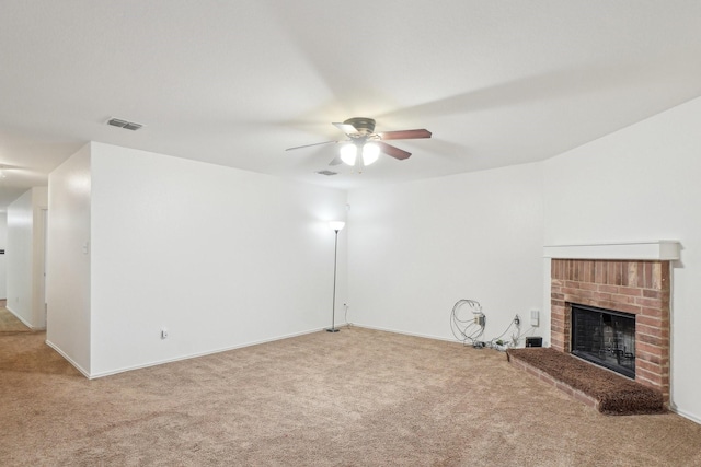 unfurnished living room with carpet flooring, a fireplace, visible vents, and ceiling fan