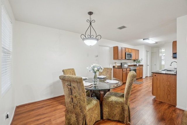 dining room featuring wood finished floors, visible vents, and baseboards