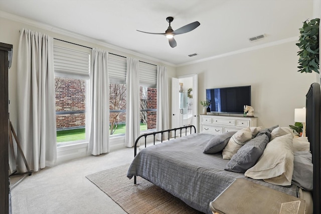 bedroom featuring ceiling fan, visible vents, light colored carpet, and ornamental molding