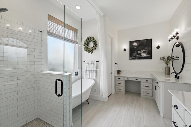 bathroom with vanity, a shower stall, and a soaking tub