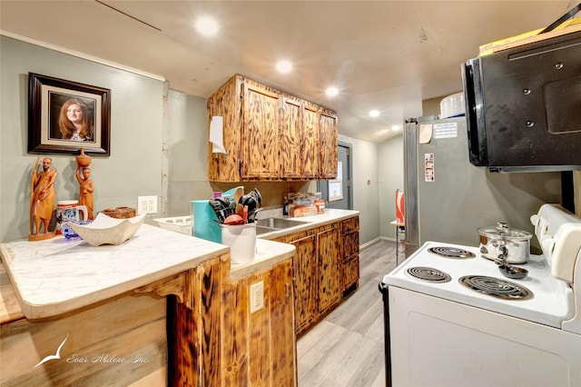 kitchen featuring white range with electric cooktop, light countertops, lofted ceiling, light wood-style flooring, and freestanding refrigerator