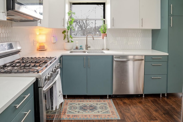 kitchen featuring a sink, stainless steel appliances, dark wood-style floors, and light countertops