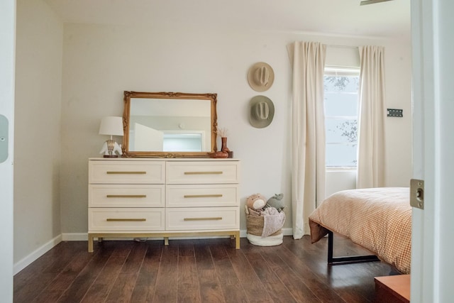 bedroom with dark wood-type flooring and baseboards