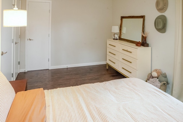 bedroom with baseboards and dark wood finished floors