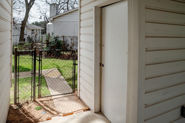 view of outbuilding featuring fence and a gate