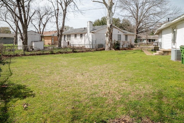 view of yard with central air condition unit, a residential view, and fence