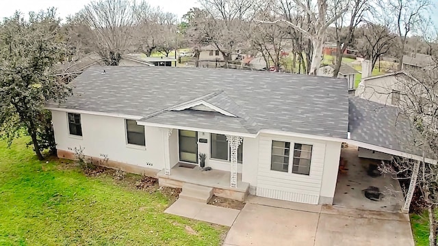 view of front of property featuring a front yard and a shingled roof