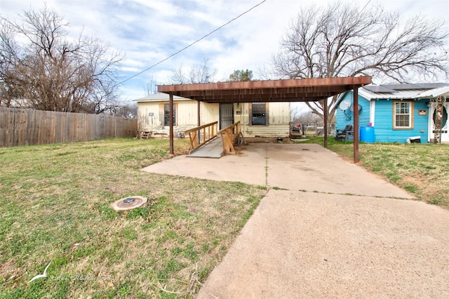 exterior space featuring entry steps, a detached carport, driveway, and fence