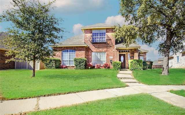 traditional-style house with brick siding and a front lawn