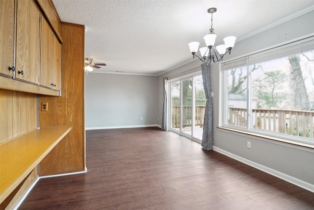 unfurnished dining area featuring baseboards, a textured ceiling, dark wood finished floors, and crown molding