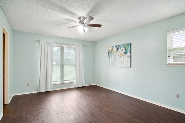 spare room featuring dark wood-style floors, baseboards, and ceiling fan