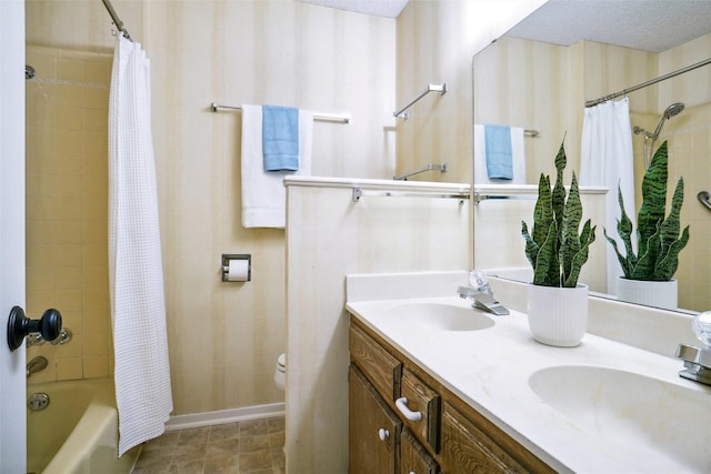 bathroom with a sink, toilet, shower / bath combo, and a textured ceiling