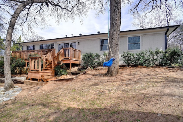 back of house with brick siding, stairway, and a deck