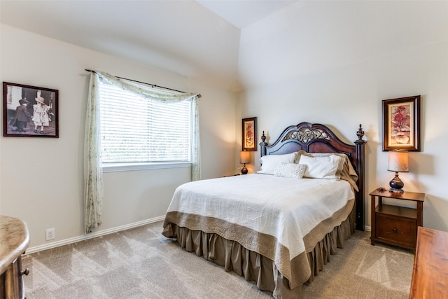 carpeted bedroom featuring baseboards and lofted ceiling