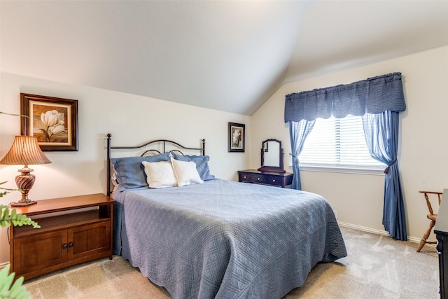 bedroom with light colored carpet, baseboards, and lofted ceiling