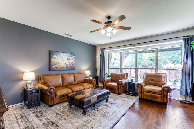 living area featuring visible vents, baseboards, a ceiling fan, and hardwood / wood-style flooring