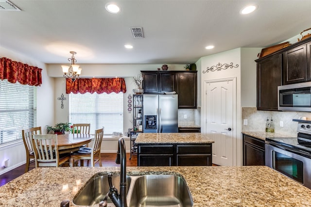 2728 Pine Trail Dr, Little Elm, TX 75068 - kitchen featuring appliances with stainless steel finishes, a sink, a chandelier, dark wood finished floors, and dark brown cabinetry