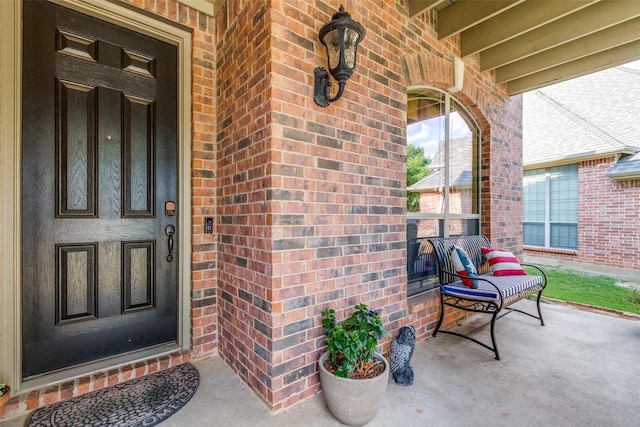 property entrance with brick siding and covered porch