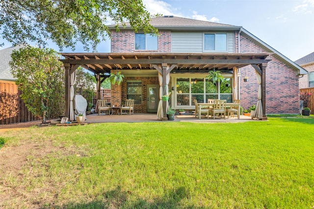 back of house with a patio area, a lawn, brick siding, and fence