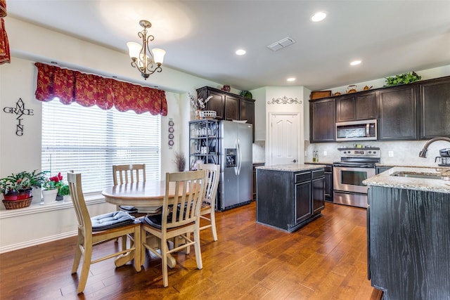 2728 Pine Trail Dr, Little Elm, TX 75068 - kitchen with appliances with stainless steel finishes, a sink, dark wood finished floors, dark brown cabinets, and recessed lighting