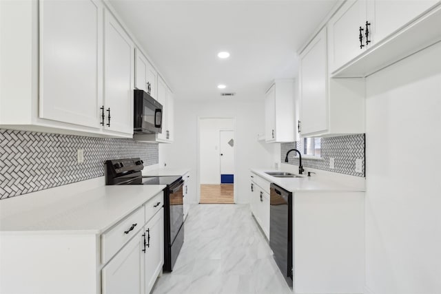 kitchen with visible vents, a sink, black appliances, light countertops, and marble finish floor