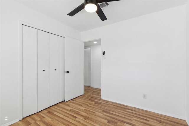 unfurnished bedroom featuring a ceiling fan, visible vents, baseboards, a closet, and light wood-type flooring