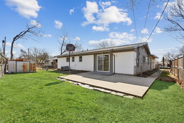 rear view of house with an outdoor structure, a lawn, a fenced backyard, and a shed