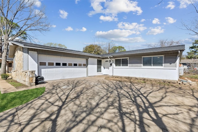 ranch-style home with fence, a garage, and driveway