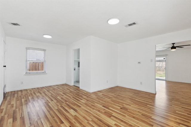 spare room featuring visible vents, baseboards, and light wood-style floors