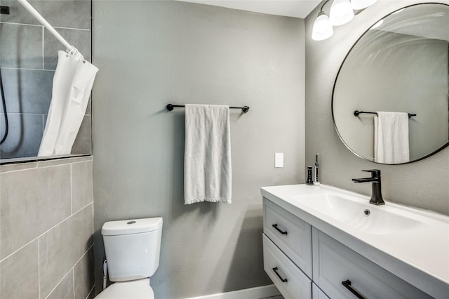 full bath with tiled shower, toilet, and vanity