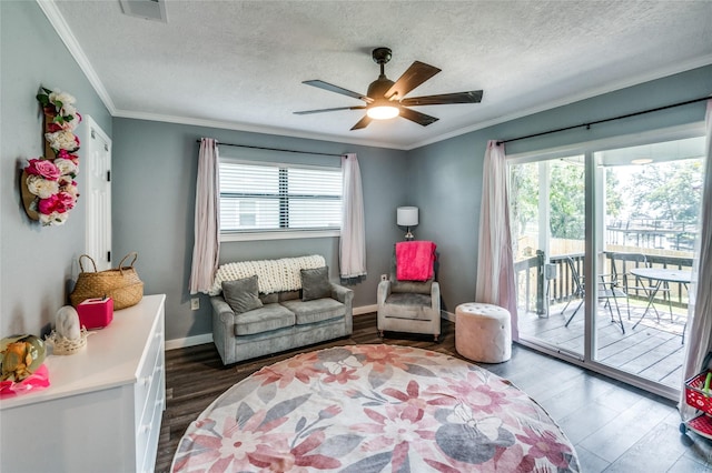 living area with a wealth of natural light, ceiling fan, dark wood-style flooring, and crown molding