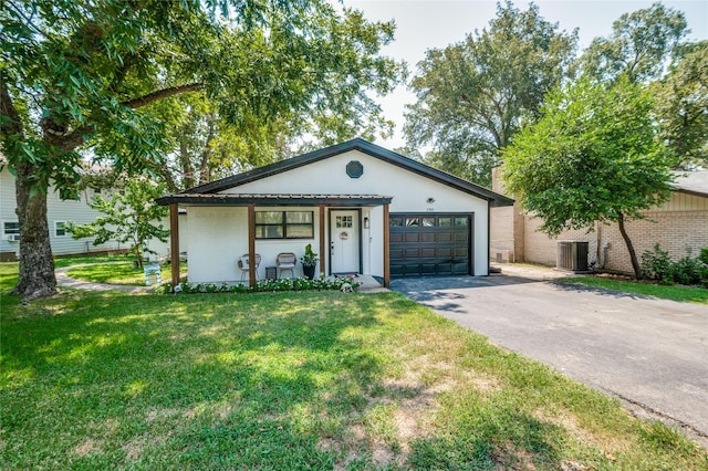 view of front of home with driveway, an attached garage, a front lawn, central air condition unit, and brick siding