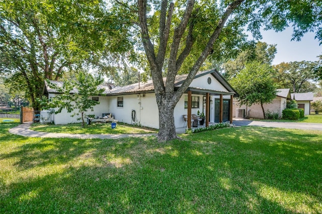 back of property featuring a lawn, driveway, a garage, and fence