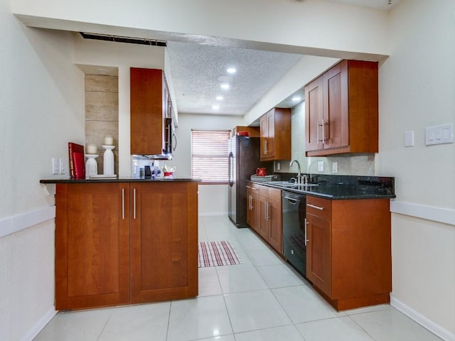 kitchen featuring a sink, a textured ceiling, brown cabinetry, and stainless steel appliances